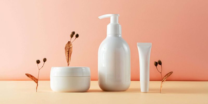 Various cosmetic bottles and natural plant parts creative still life beauty photography. Lotion, moisture cream and lip balm blank empty mockup Various cosmetic bottles and natural plant parts creative still life beauty photography. Lotion, moisture cream and lip balm blank empty mockup. Trendy composition